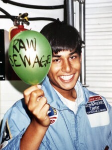 Photo of Parag Mallick at Space Camp holding up a balloon that says "Raw Sewage"