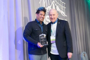 Parag Mallick receiving the Gil S. Omenn Computational Proteomics Award from Gil S. Omenn at US HUPO 2024